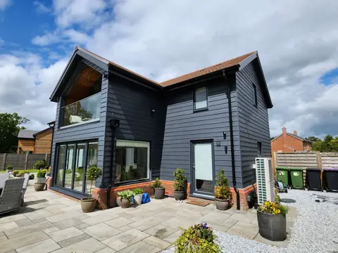 Dark cladding around a glazed gable — CG Cladding Solutions