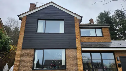 A dark feature on a brick house front — CG Cladding Solutions